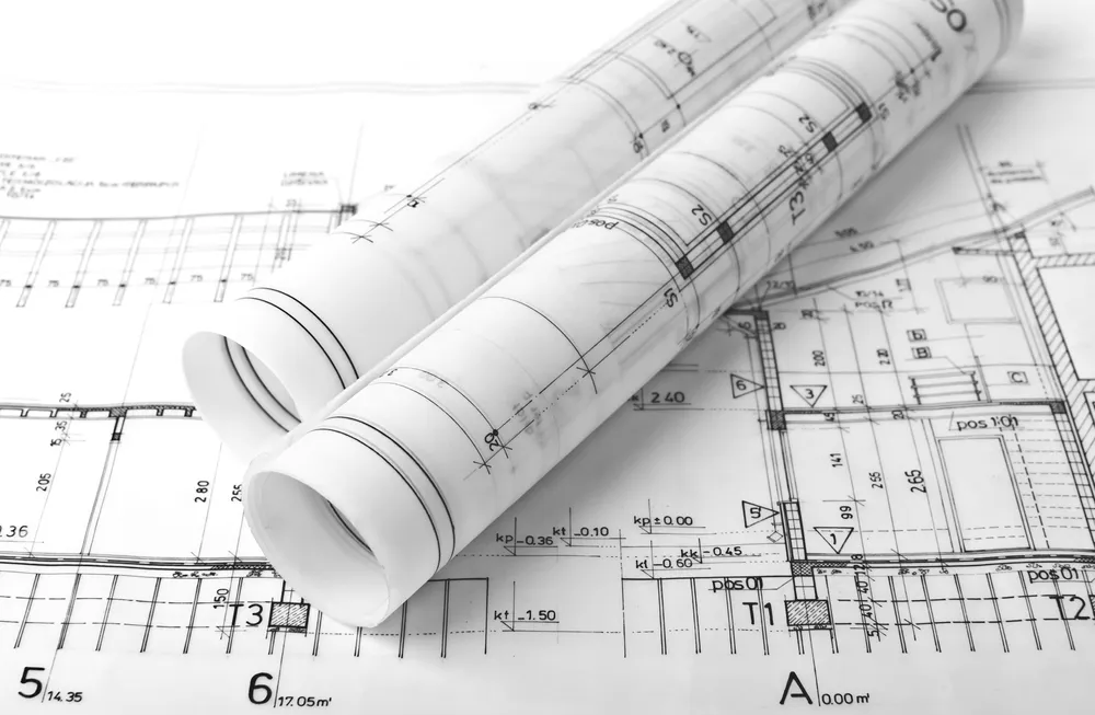 Opgerolde bouwplannen op een technische tekening