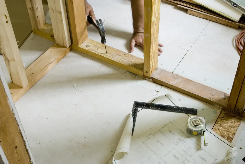 Houten regelwerk voor een binnenwand met gereedschap op de vloer
