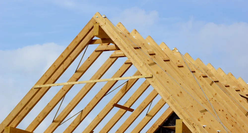 Houten dakgebinte tegen een blauwe lucht